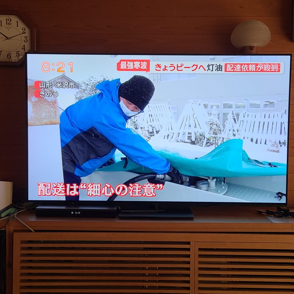 テレビ局のニュース番組にて、山形県米沢市での灯油配送業務が寒波対応の事例として取材・放送された様子